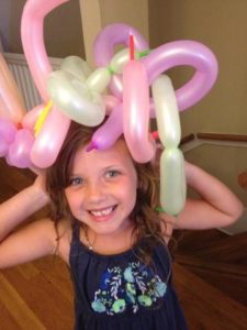 A kid playing with balloons