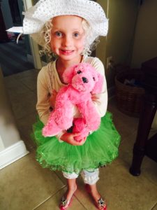 A kid carrying a pink puppy doll